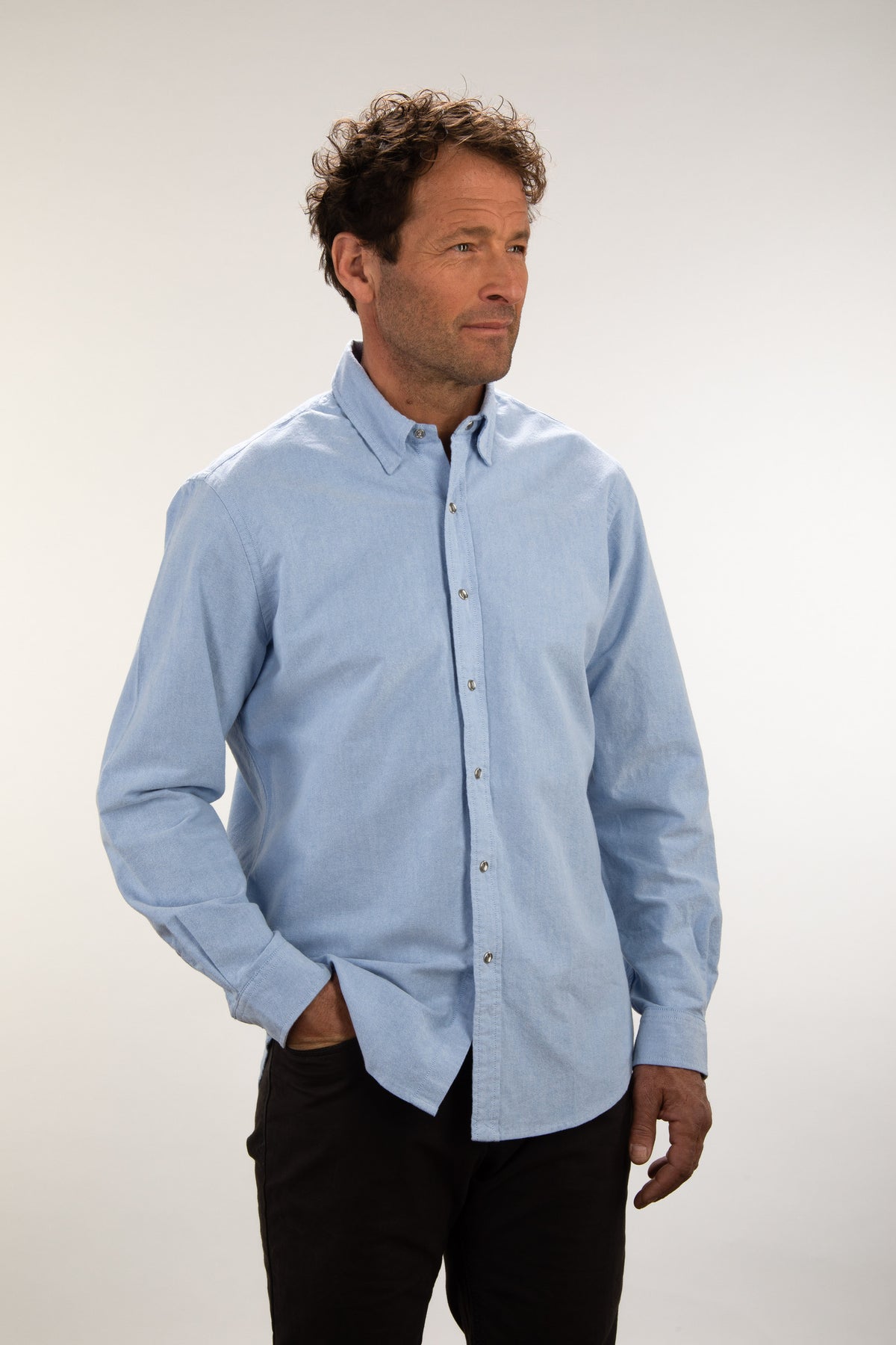 Man wearing the Unbuttoned blue oxford snap shirt